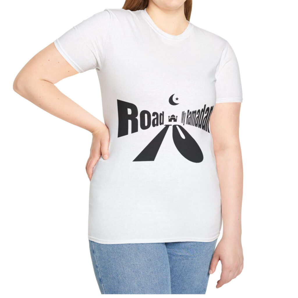 A cheerful woman wearing a white t-shirt that reads "Road to Ramadan," radiates positivity and style.
